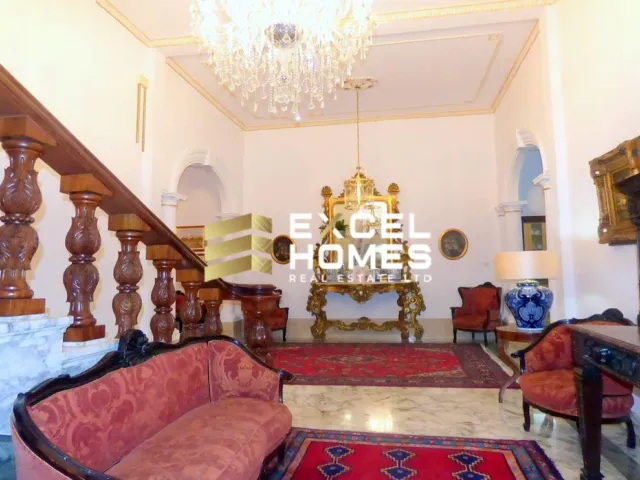 a living room with a large red couch and a large clock 