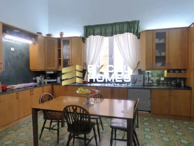 a kitchen with a table and chairs and a refrigerator 