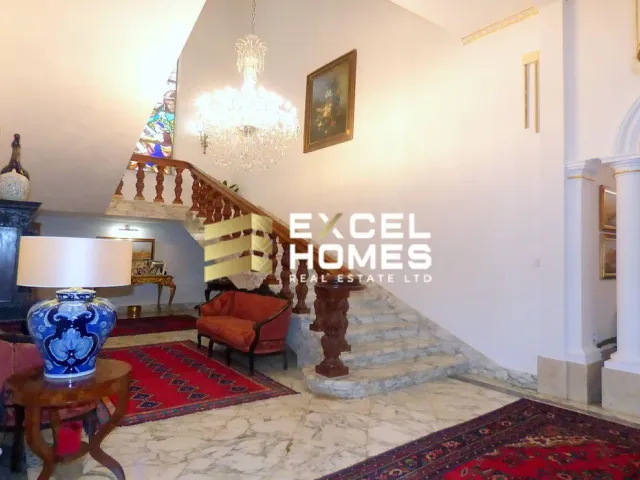 a living room with a couch, chairs, and a clock 