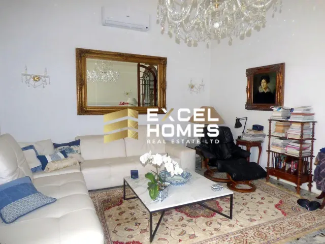 a living room with a couch, table, chairs and a mirror 
