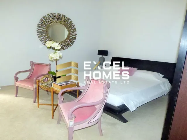 a bedroom with a bed, chair, mirror and a lamp 