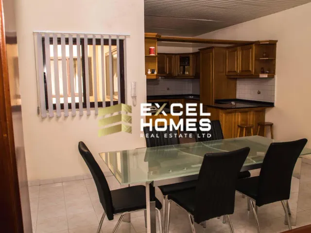 a kitchen with a table and chairs and a refrigerator