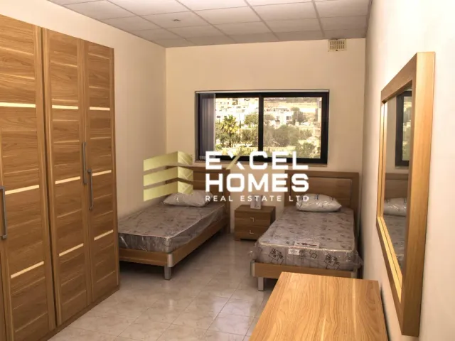 a bedroom with a bed, desk, and a window