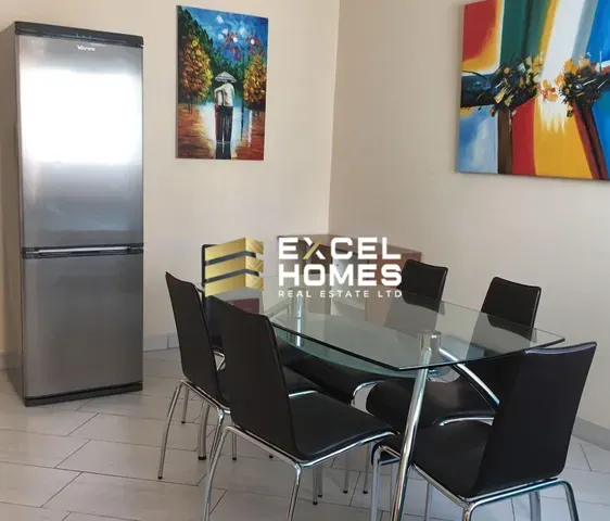 a kitchen with a table and chairs and a refrigerator
