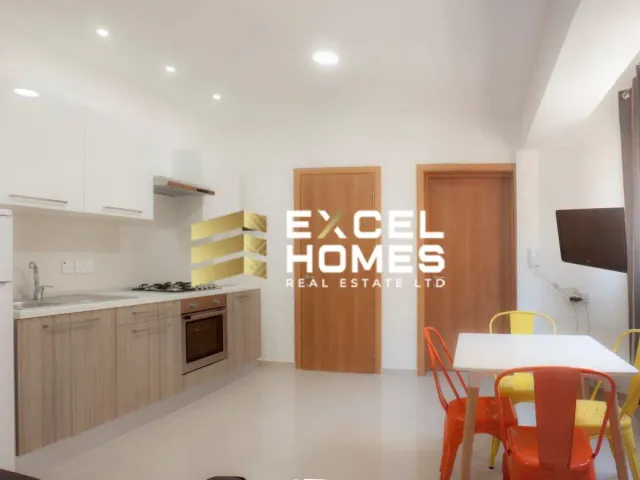 a kitchen with a refrigerator, microwave, and a table