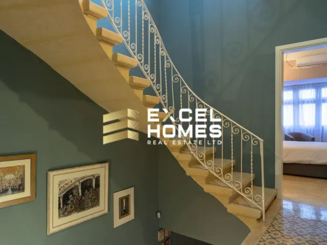 a staircase leading up to a balcony with a painting on it