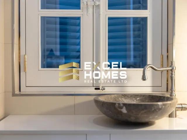a sink with a window and a bowl on top of it