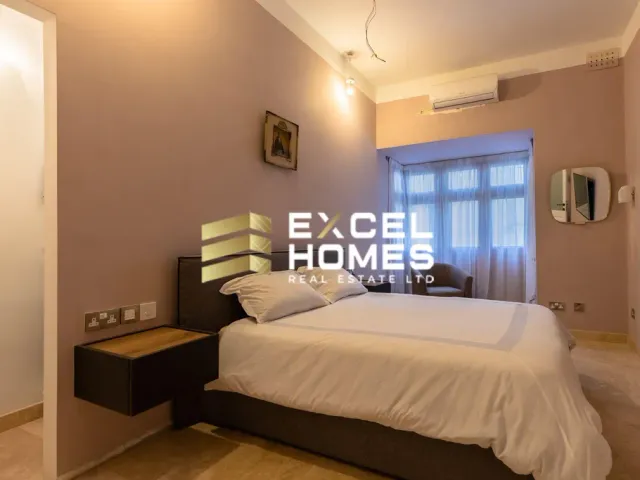 a bedroom with a bed, a desk and a window