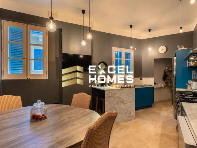a kitchen with a table, chairs, and a refrigerator