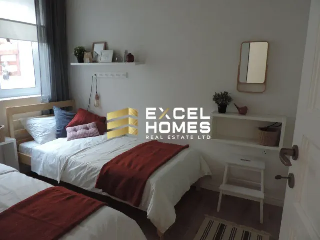 a bedroom with a bed, desk, and a lamp