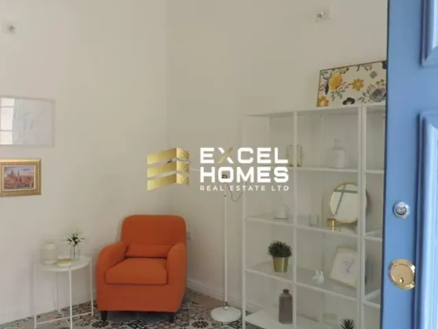 a room with a chair, a shelf and a picture on the wall