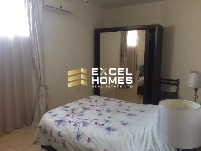 a bedroom with a bed, mirror and a lamp