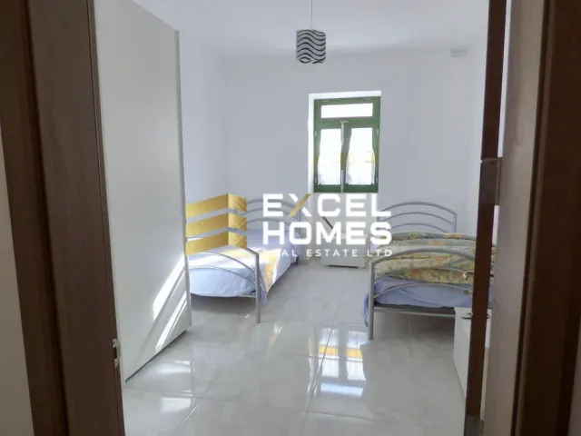 a bedroom with a bed, desk, and a window