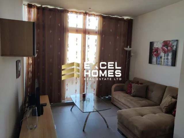 a living room with a couch, coffee table and a window