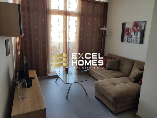 a living room with a couch, coffee table and a window