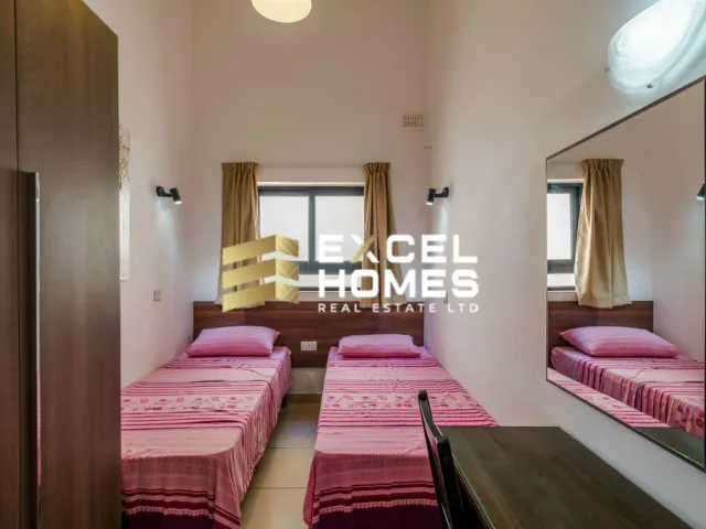 a bedroom with two beds and a desk 
