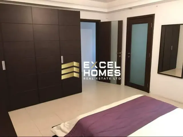 a bedroom with a bed, desk, and a mirror