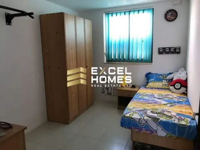 a bedroom with a bed, desk, and a window