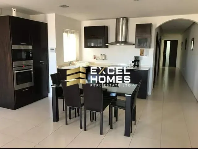 a kitchen with a table and chairs and a refrigerator