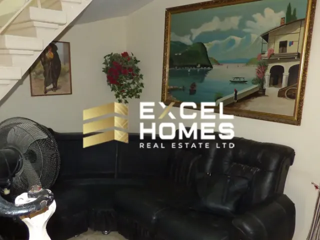 a living room with a couch, chair, and a painting