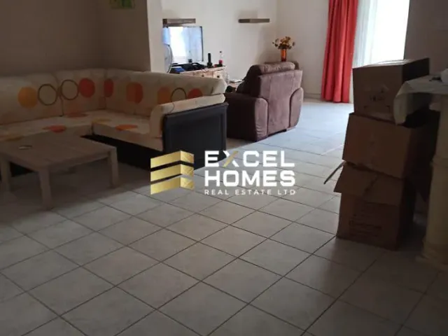 a living room with a couch, chair, and a laptop 
