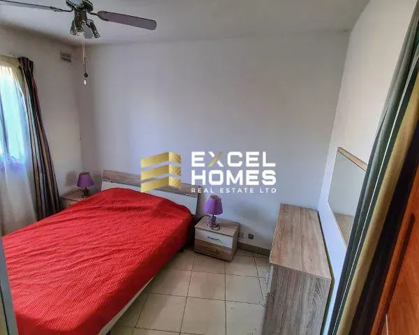 a bedroom with a bed, a desk and a mirror