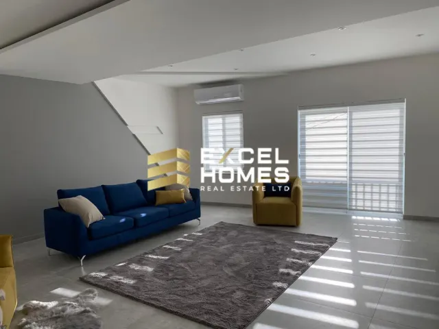 a living room with a couch, chair, and a window