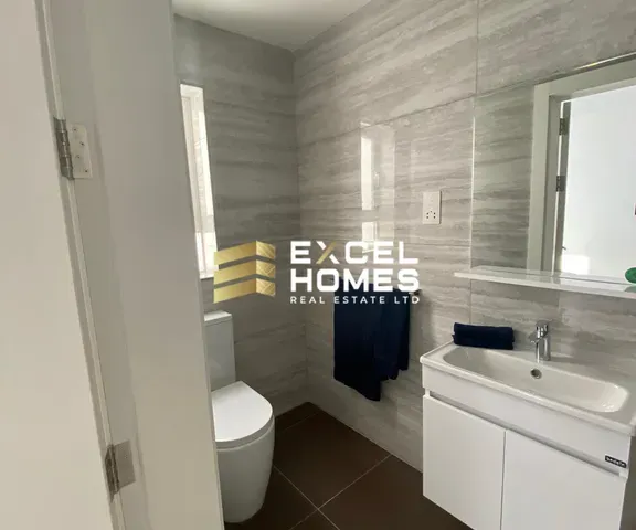 a bathroom with a toilet, sink, and mirror