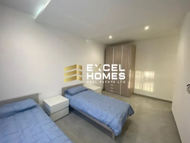 a bedroom with a bed, desk, and a television