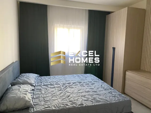 a bed with a white bedspread and a blue comforter