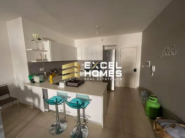 a kitchen with a sink, counter, and a refrigerator