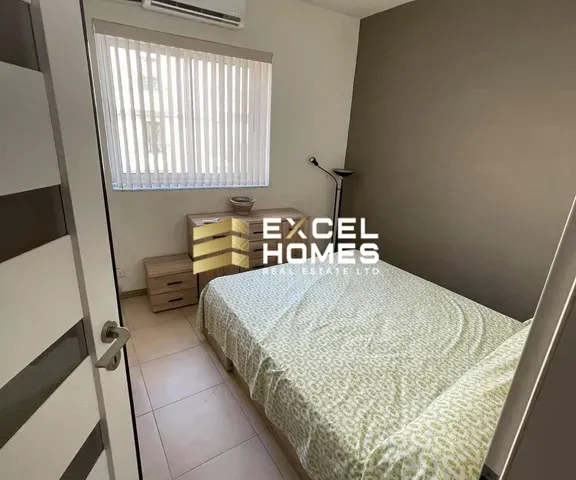 a bedroom with a bed, a desk and a window