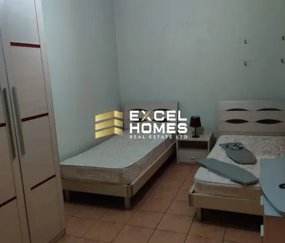 a bedroom with a bed, desk, and a lamp