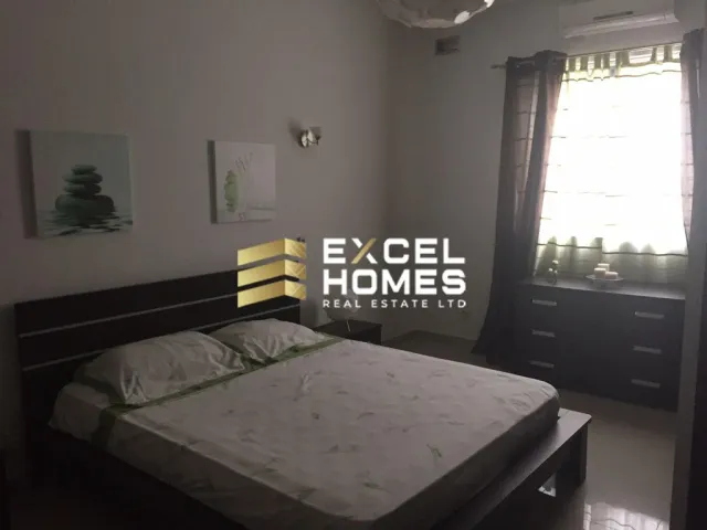 a bed with a white bedspread and a lamp