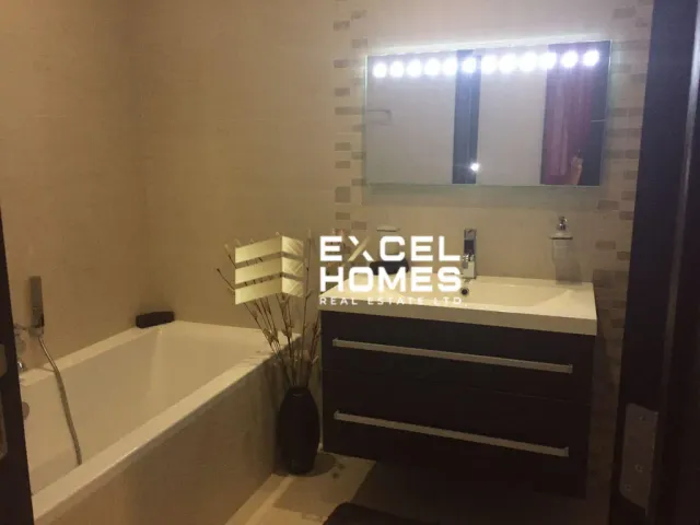 a bathroom with a tub, sink, mirror and bathtub