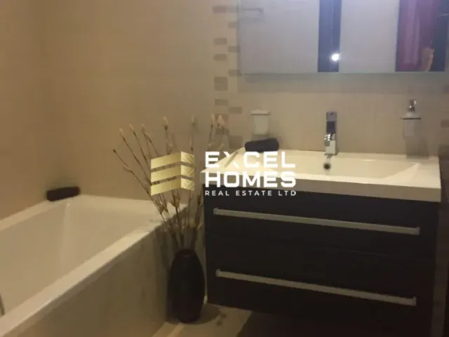 a bathroom with a bath tub, sink, and mirror