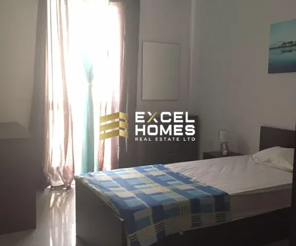 a bed with a white bedspread and a blue comforter