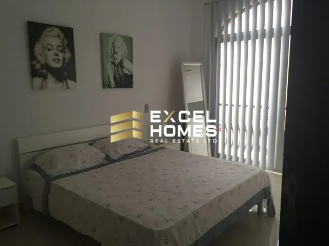 a bedroom with a bed, a desk and a window