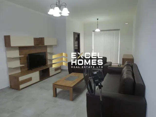 a living room with a couch, coffee table and a television