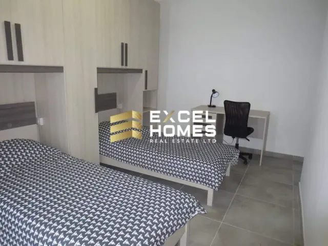 a bedroom with a bed, desk, and chair