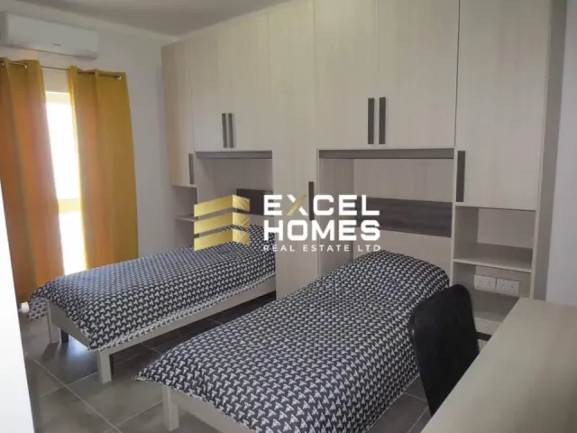 a room with two beds and a desk