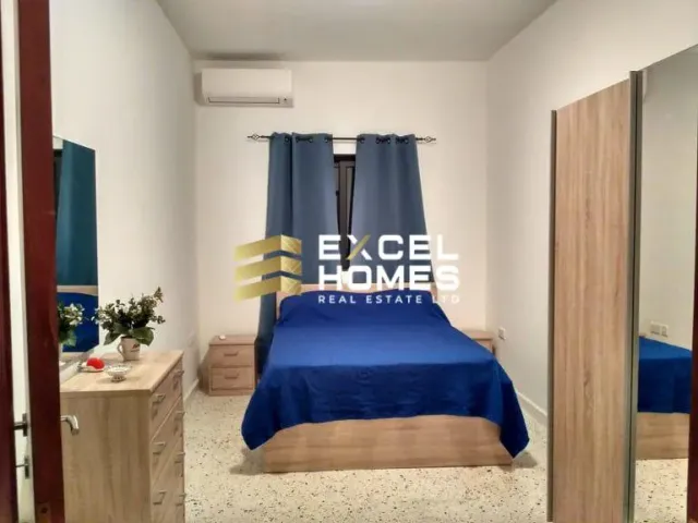 a bedroom with a bed, desk, and a mirror