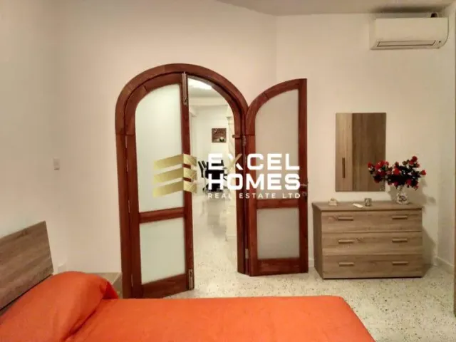 a bedroom with a bed, mirror, and a dresser