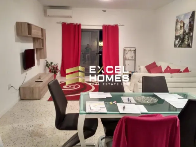 a woman is sitting in a living room with a laptop