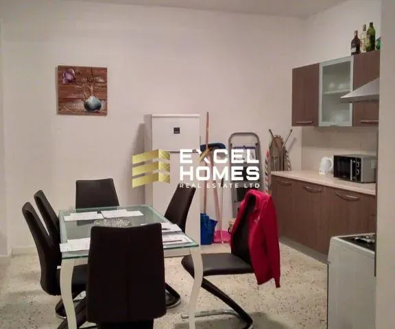 a kitchen with a table, chairs, and a refrigerator