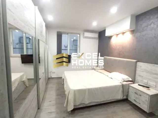 a hotel room with a bed, a desk and a mirror