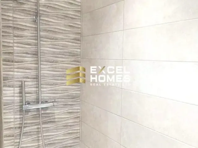 a bathroom with a white wall and a blue and white tile floor