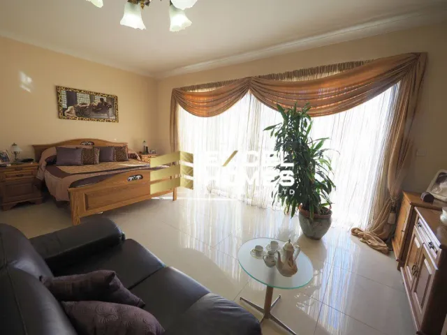 a living room with a couch, a table and a window 