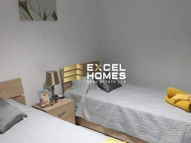 a bedroom with a bed, desk, and a television