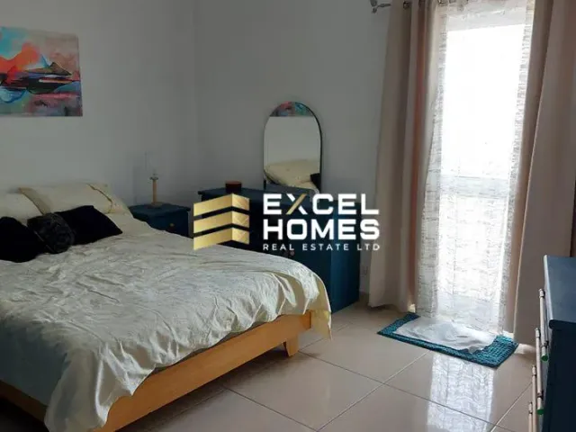 a bedroom with a bed, desk, and a lamp